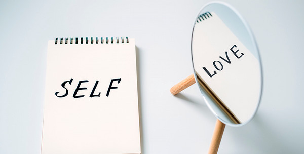 notepad with "self" reflecting in mirror as "love"